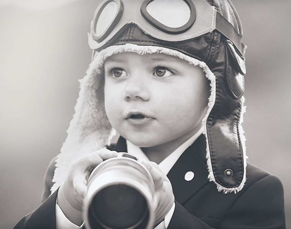 Enfant en tenue d'aviateur observant à la longue-vue